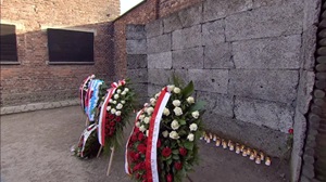 image of wreaths laid at a wall at Auschwitz