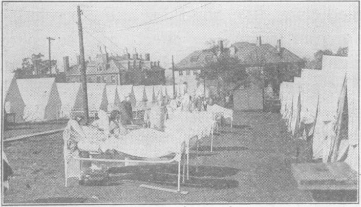 Black and white photo of Camp Brooks field hospital, showing patients in their hospital beds out in the open, near their tents.